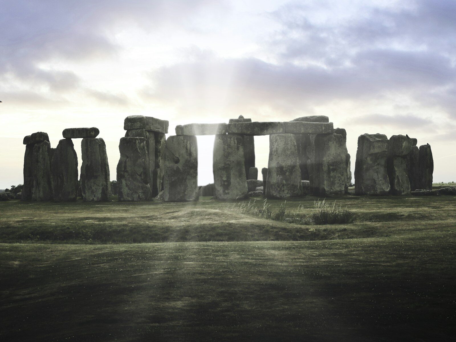 Stonehenge at dawn with light breaking through the ancient stones