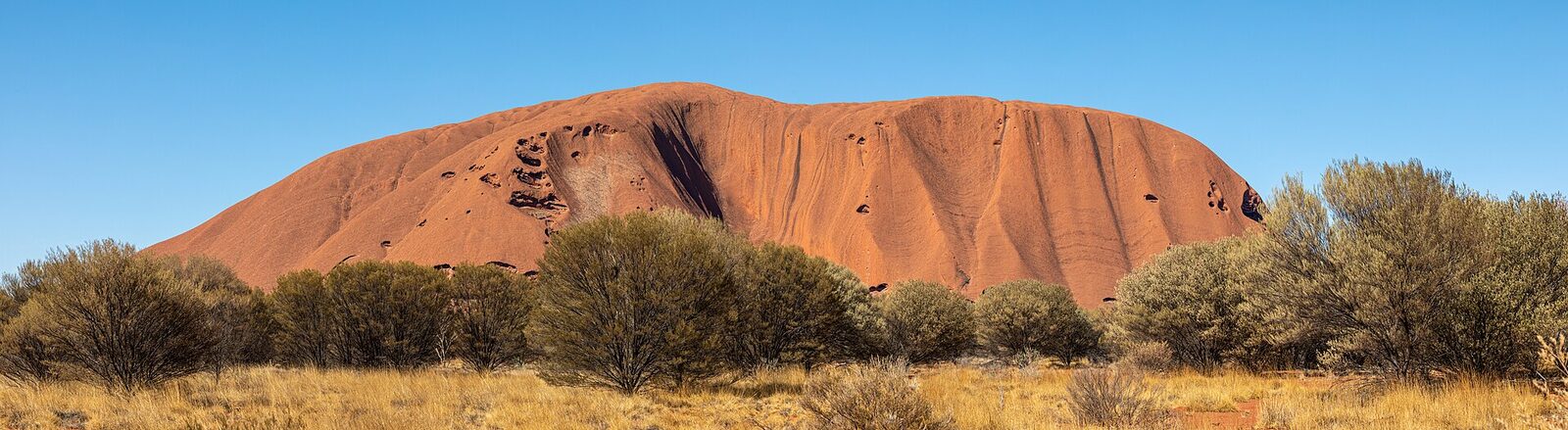 Uluru glowing red above the desert scrub of central Australia